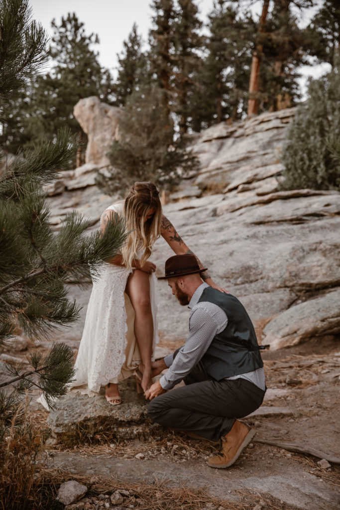 Groom helping bride put her shoes on