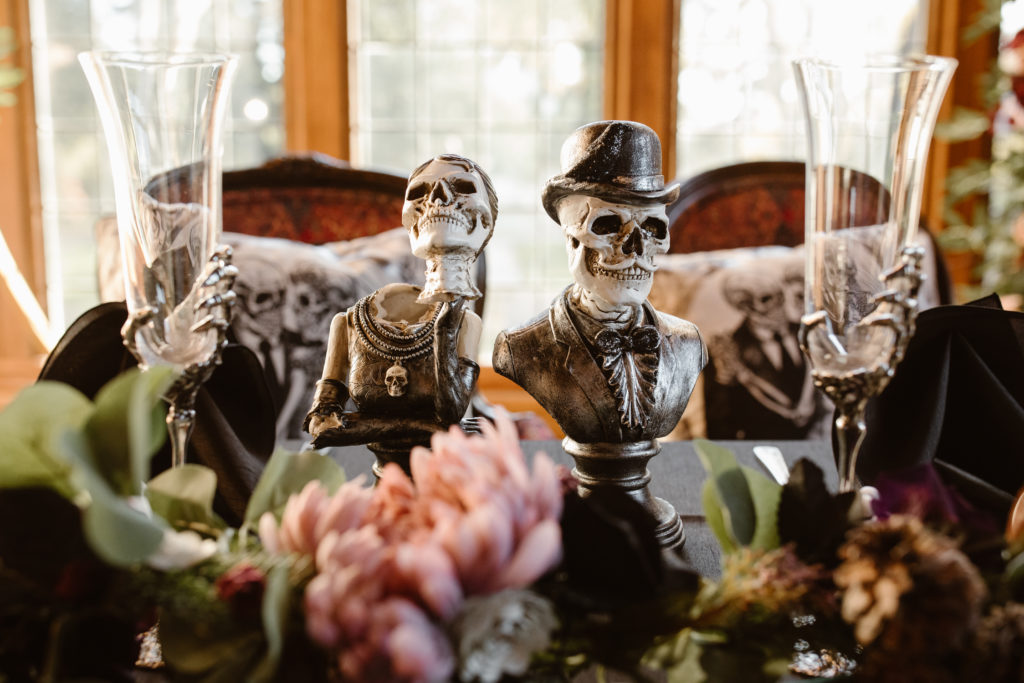 Head table at a wedding with skeleton bride and groom.