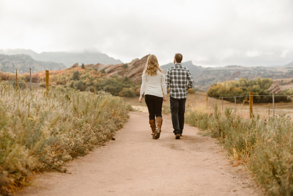 Couple holding hands walking down path