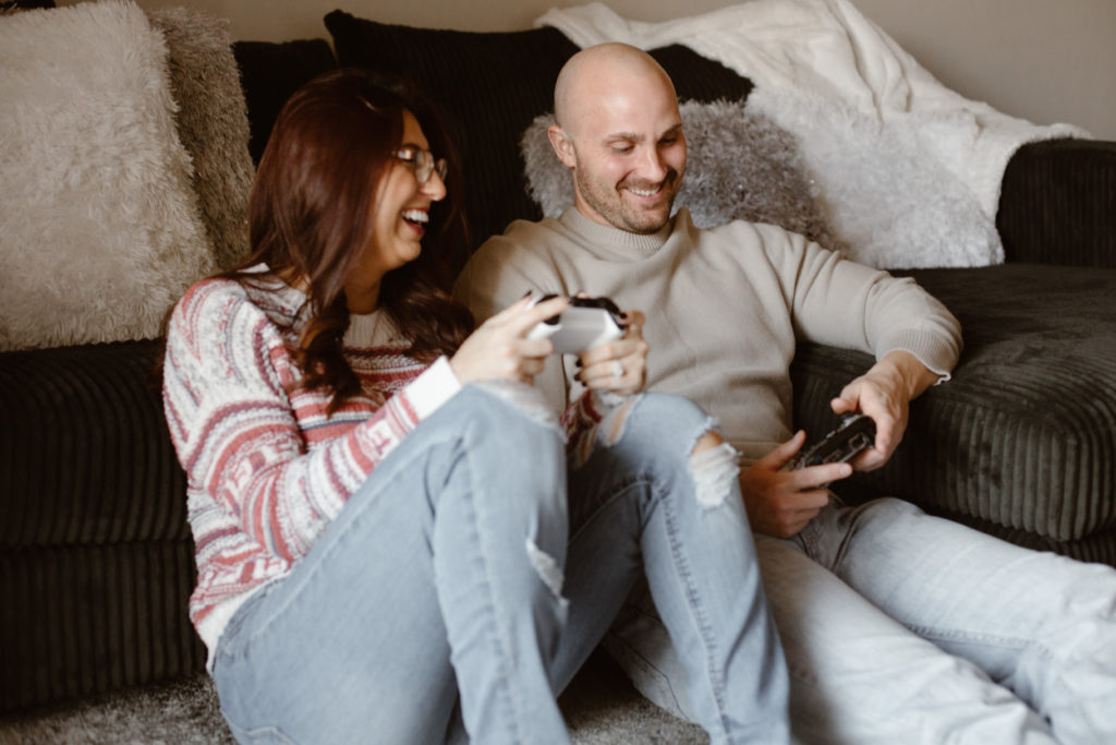 Couple playing video games smiling in their living room