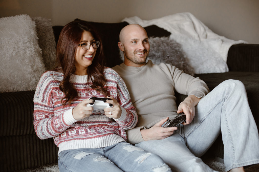 Couple playing video games smiling in their living room
