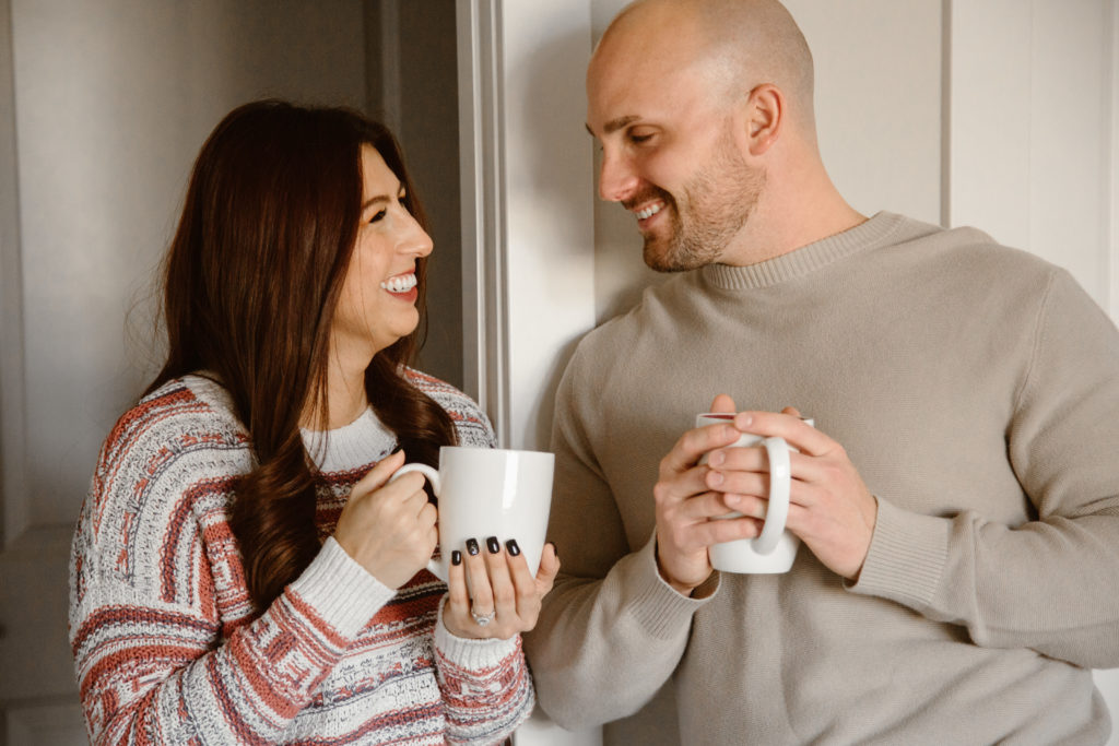 Couple drinking coffee smiling at each other