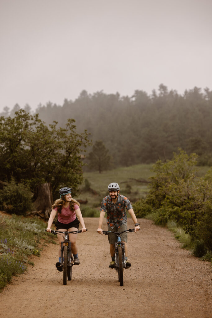 Engaged couple riding their mountain bikes on a dirt path