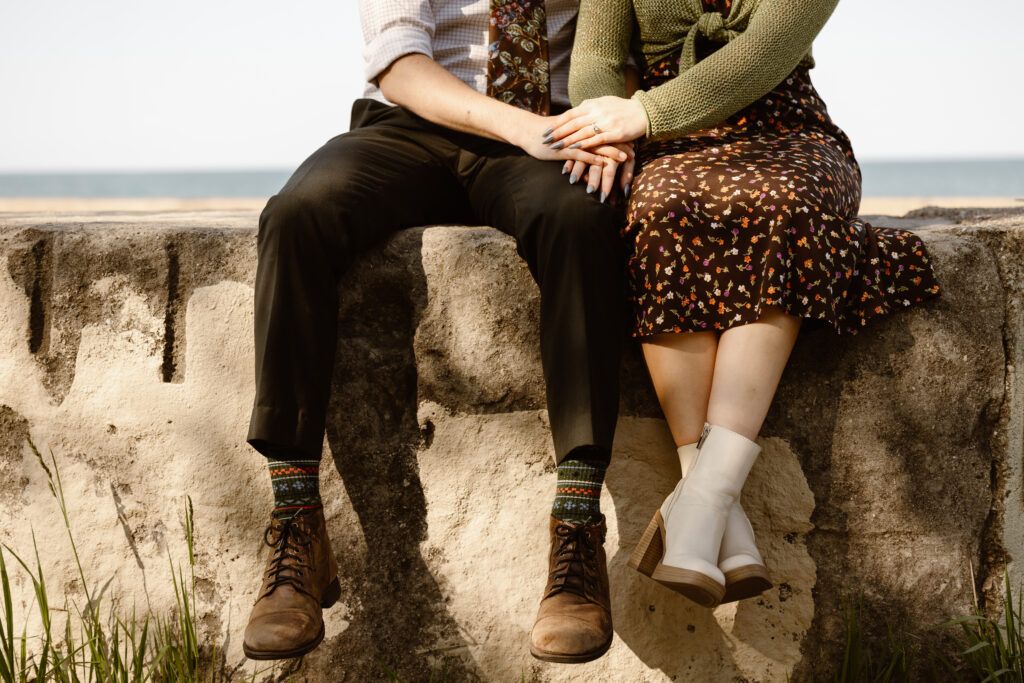 Couple sitting on a stone wall holding hands