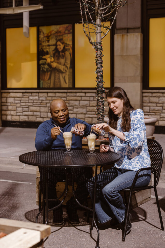 Couple making root beer floats at an outside table