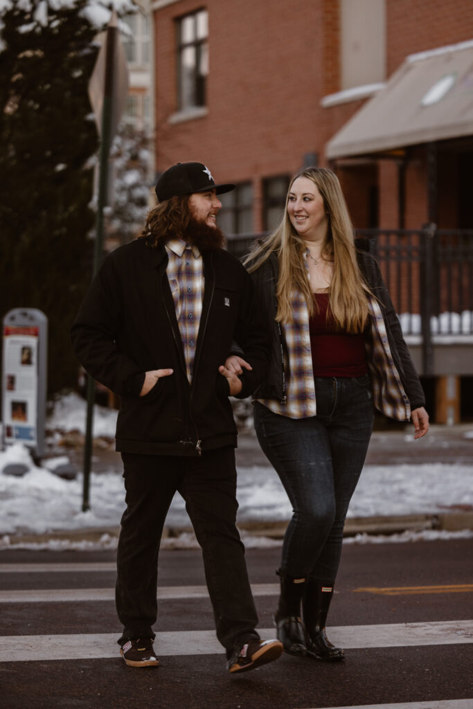 Couple walking across a sidewalk arm in arm