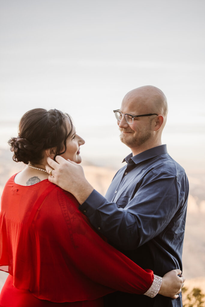 Man looking at his fiancé, tucking a strand of hair behind her ear