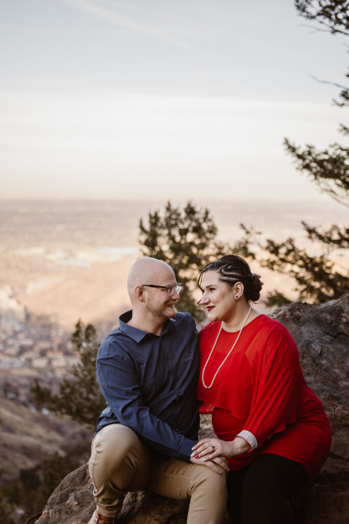 Couple looking at each other on a mountain top with the city of Golden in the background