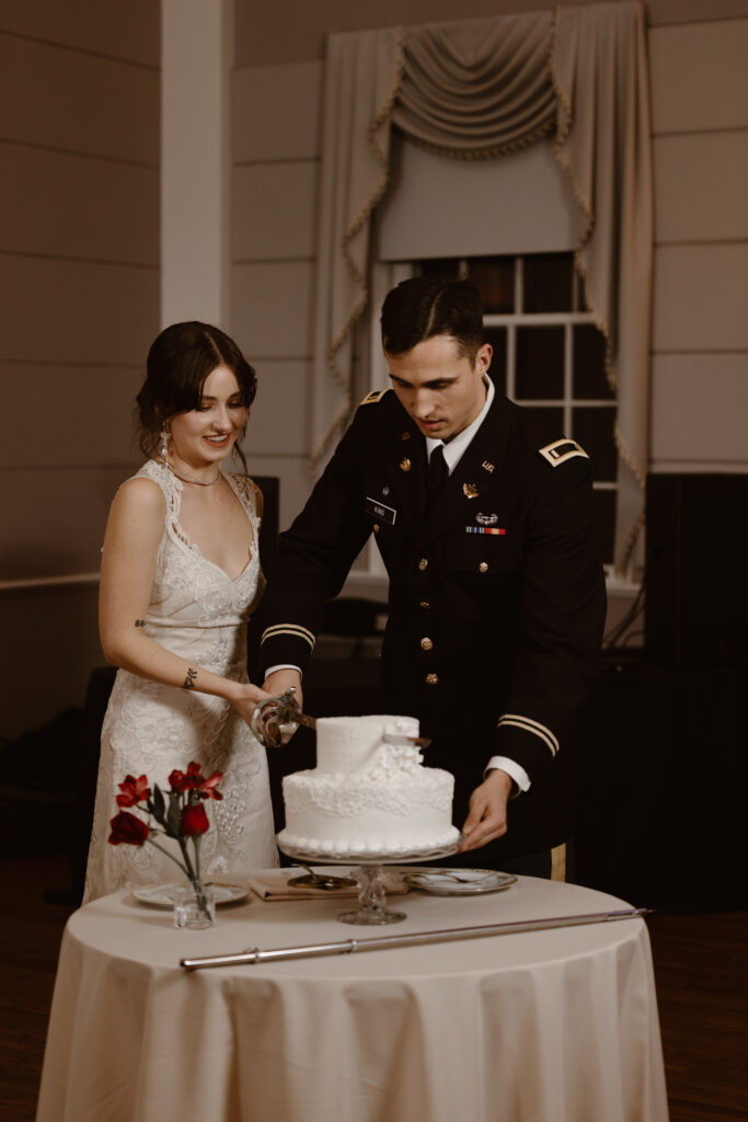 Bride and groom cutting their wedding cake with a sword