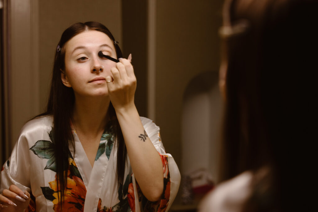 Bride to be applying makeup in mirror