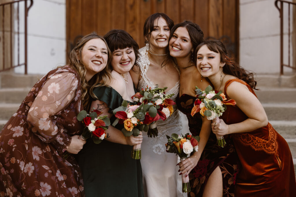 Bride and her bridesmaids squished together all smiling
