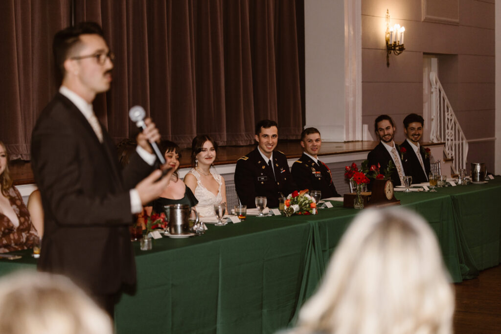 Groomsmen giving a speech with bridal party in the background