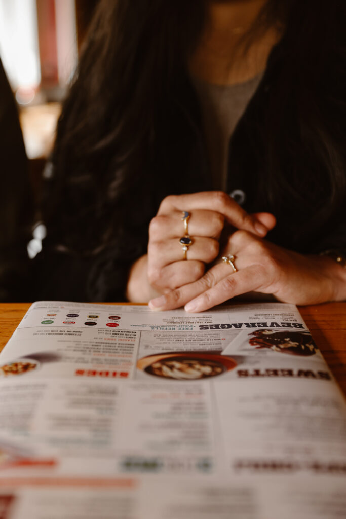 Woman with her hand and engagement ring on a menu at Chili's