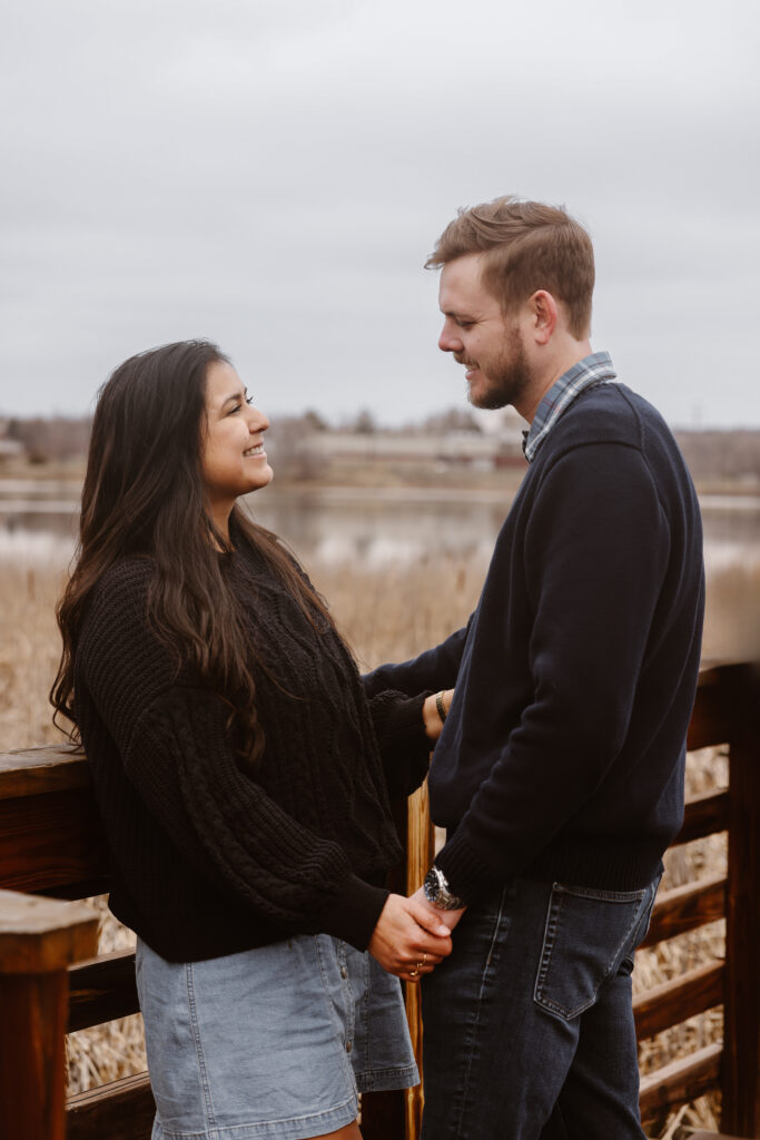 Couple facing each other holding hands smiling