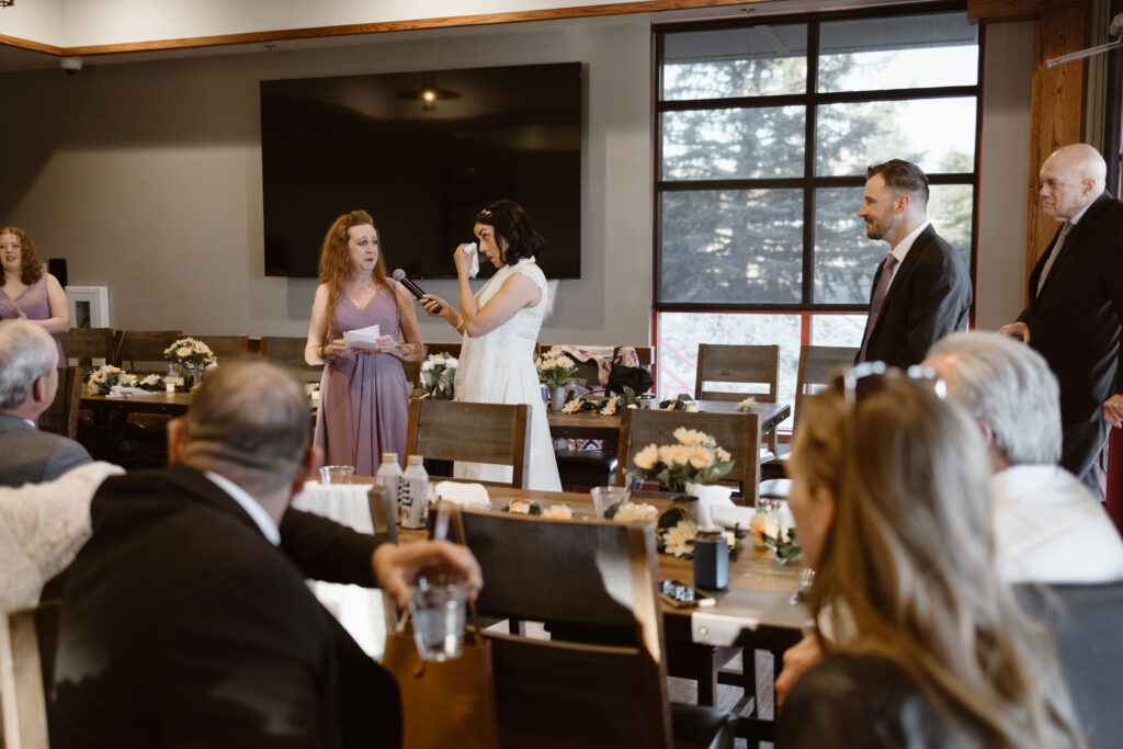 Bride wiping away tears during emotional wedding toast at Walnut Creek Golf Preserve reception in Westminster Colorado captured by Colorado wedding photographer.