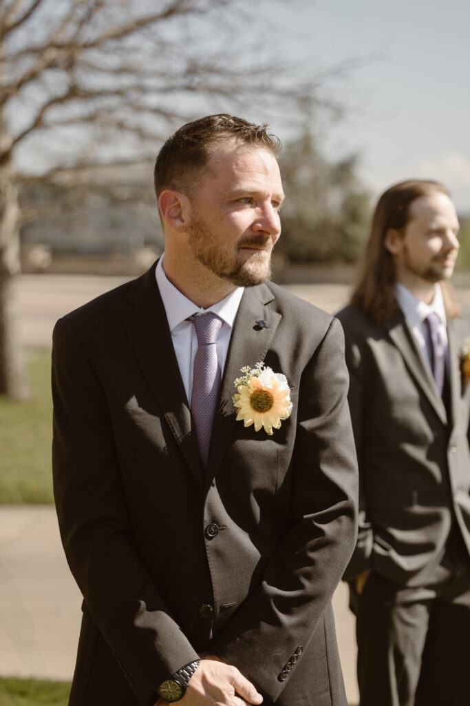 Groom watching his bride walk down the aisle