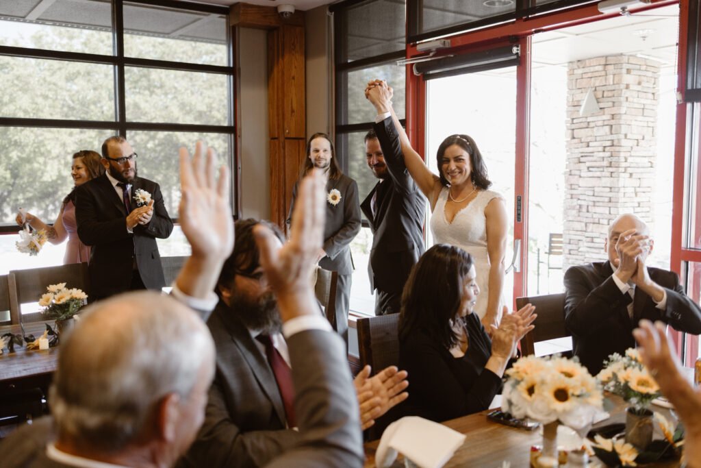 Bride and groom holding hands walking into their reception