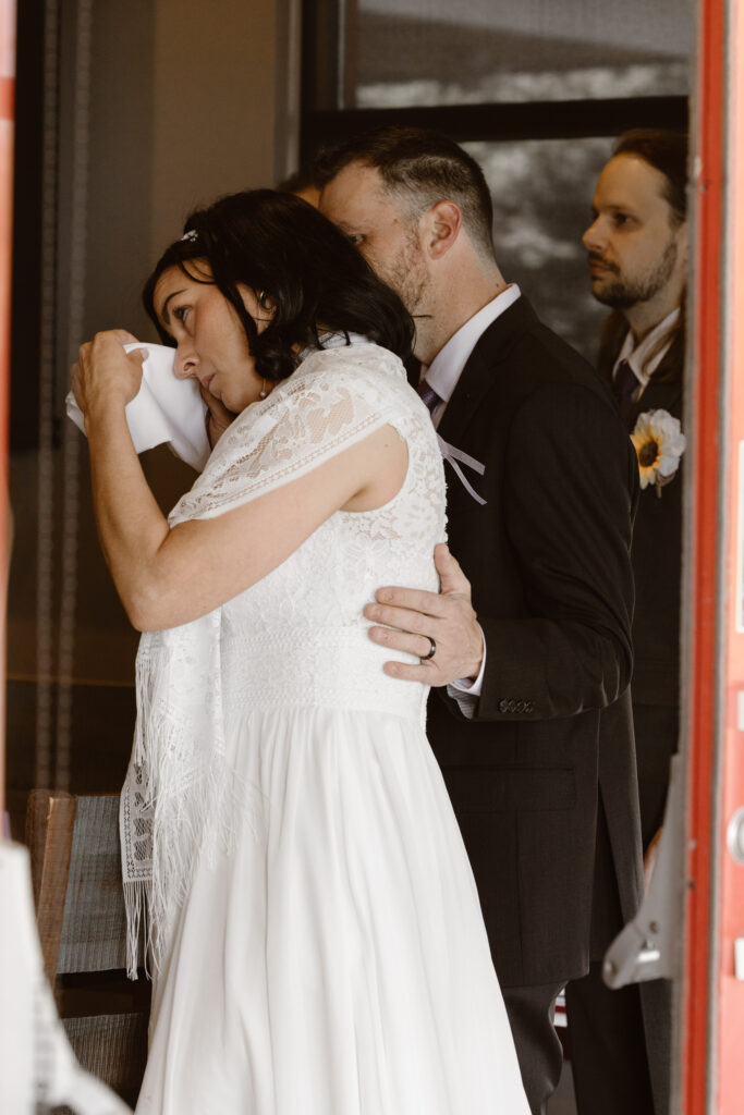 Bride wiping a tear away as her father gives a toast at the reception