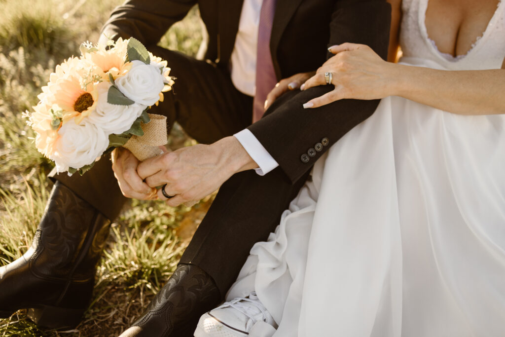 Close-up of bride and groom holding sunflower bouquet during golden hour portraits at Walnut Creek Golf Preserve wedding in Westminster Colorado by Colorado wedding photographer.
